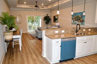 Kitchen with a raised ceiling, white cabinetry, di
