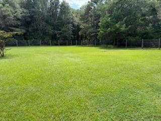 View of grassy yard with a forest view