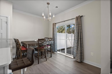 Dining space featuring ornamental molding, hardwoo