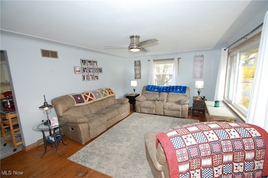 Living room with wood finished floors and a ceiling fan