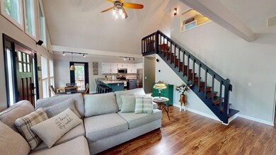 Living area featuring stairs, a towering ceiling, 