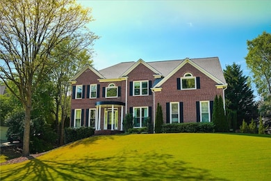 Colonial home featuring a front yard and brick sid