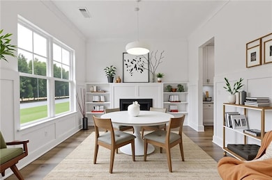 Dining room with crown molding, wood finished floors, and a fireplace