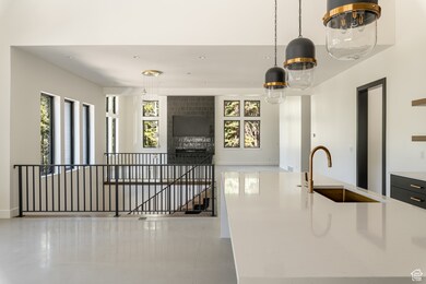 Kitchen with plenty of natural light, decorative light fixtures, and light stone counters