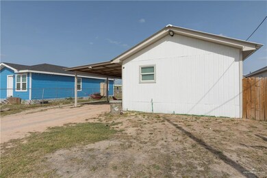 View of property exterior with dirt driveway, an attached carport, and fence