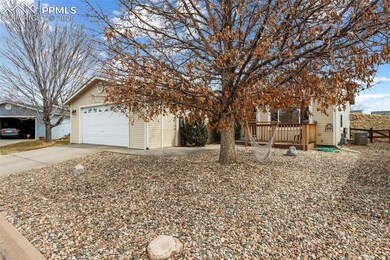 View of front of home with driveway, an attached garage, central air condition unit, and an outdoor structure