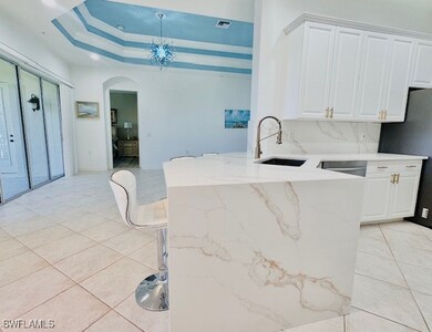 Kitchen with waterfall quartz counters, light tile