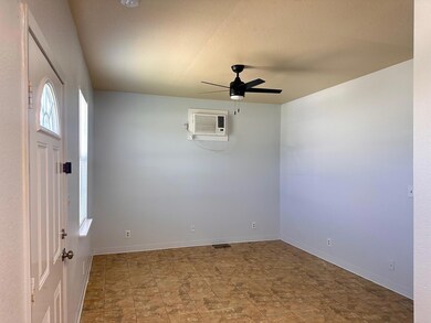 Empty room featuring a wall mounted AC, ceiling f