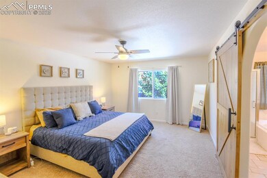 Bedroom with a barn door, baseboards, light colore