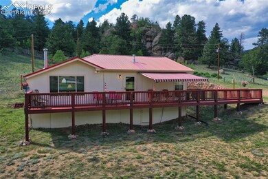 Rear view of property featuring a deck and a lawn