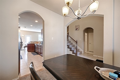 Dining space featuring light tile patterned floors, a chandelier, stairs, and recessed lighting