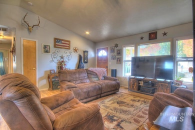 Living room featuring vaulted ceiling and wood finished floors