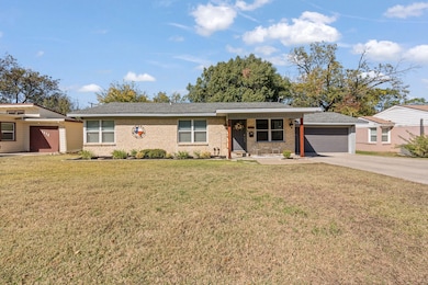 Ranch-style home with brick siding, a front lawn, driveway, a porch, and a garage