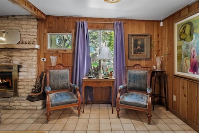 Living area featuring wood walls, a fireplace, and tile patterned floors