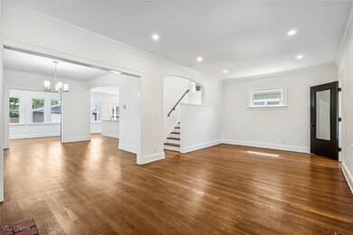 Living room with crown molding, dark hardwood flooring, and a fireplace