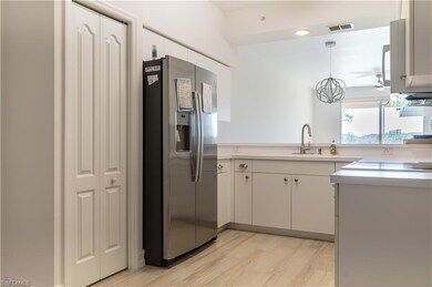 Kitchen with light countertops, a sink, light wood