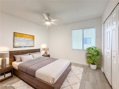 Bedroom featuring light tile patterned flooring, a closet, and a ceiling fan