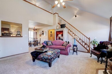 Carpeted living room with ceiling fan with high va