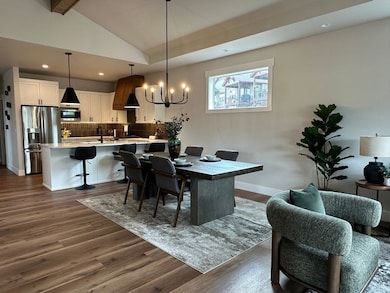 Dining space with a chandelier, dark wood-style floors, and recessed lighting
