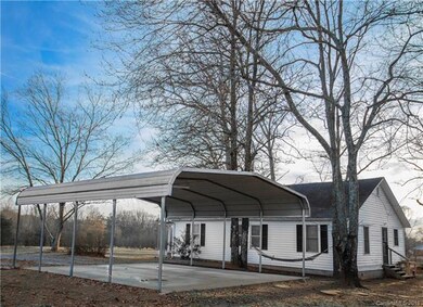 Side and rear view of home with large carport