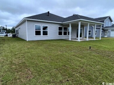Back of house with a yard, cooling unit, and a pat
