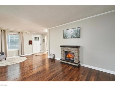 Living room featuring a textured ceiling, a fireplace, dark hardwood floors, and crown molding