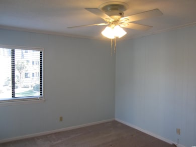 Empty room featuring crown molding and ceiling fan