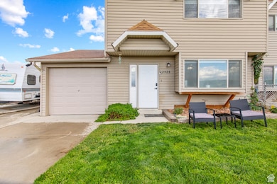 View of front of house with a front yard, driveway, and an attached garage