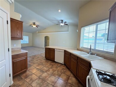 Kitchen with arched walkways, a sink, a ceiling fa