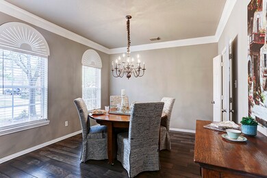 Formal dining just off of the entry features gorgeous windows with custom arch shutters, thick crown molding, and a warm chandelier in this expansive room ready for your special gatherings.  This room also converts well into additional flex space to be used otherwise.