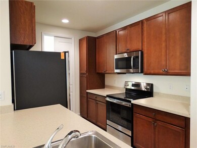 Kitchen with stainless steel appliances, light countertops, recessed lighting, and a sink