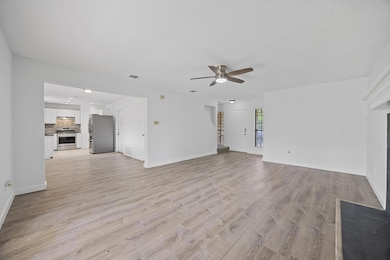 Unfurnished living room featuring a ceiling fan, 