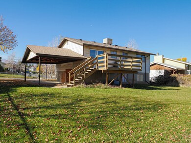 Rear view of house featuring stairway, a lawn, and a deck