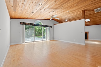 Spare room with wood ceiling, a ceiling fan, lofted ceiling, light wood-style flooring, and a fireplace