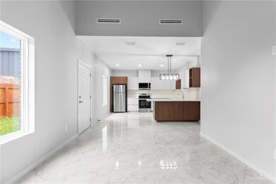 Kitchen featuring a kitchen island, appliances with stainless steel finishes, sink, and decorative light fixtures