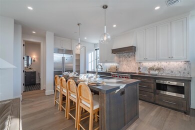 Kitchen with white cabinetry, sink, hanging light 