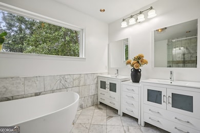 Upstairs, the luxurious Primary Suite feels like a private retreat, showcasing a Walk-In Closet and a beautiful Spa-Style Bath with a 6-foot Picture Window, a large Soaking Tub, and an oversized Double Spa Shower