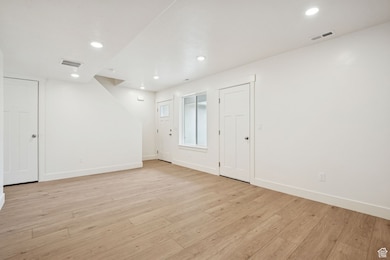 Empty room featuring light wood finished floors and recessed lighting