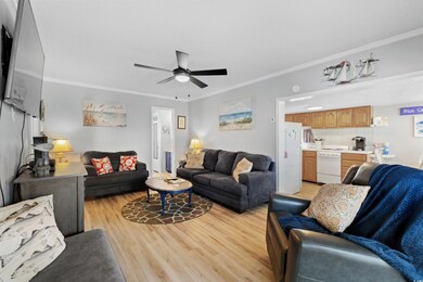 Living area with light wood finished floors, ceiling fan, and crown molding