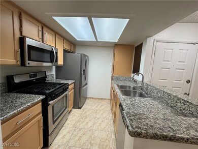 Kitchen featuring baseboards, dark stone counters,