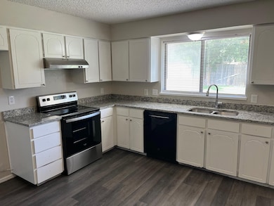 Kitchen featuring white cabinetry, electric stove, light stone countertops, dishwasher, and dark wood-style floors