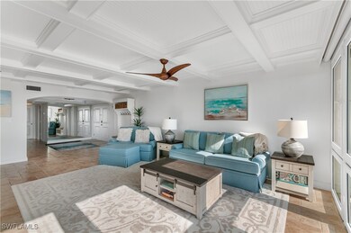 Living room featuring arched walkways, coffered ce
