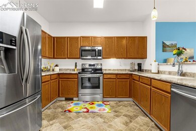 Kitchen featuring light countertops, a sink, appli