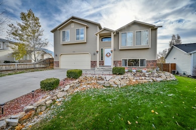 Bi-level home featuring concrete driveway, an attached garage, and brick siding