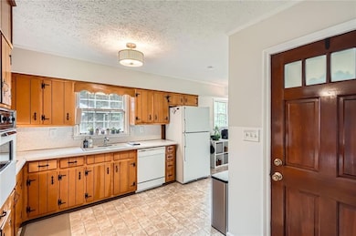 Kitchen featuring white appliances, spotless woode