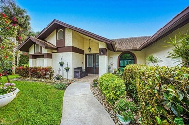 Property entrance with a shingled roof, a lawn, an