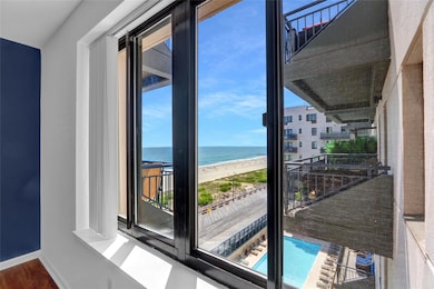 Balcony featuring view of water and beach