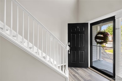 Entryway with LVP flooring, stairs, and a high cei