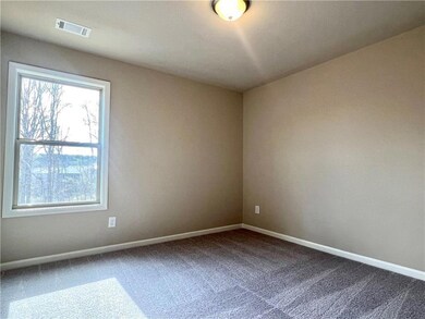 Spare room featuring carpet flooring and baseboards