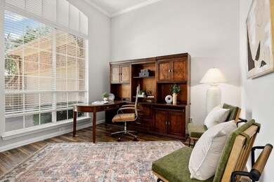 Office space featuring a wealth of natural light, ornamental molding, and dark hardwood / wood-style flooring